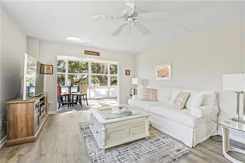 a living room with furniture a flat screen tv and a window