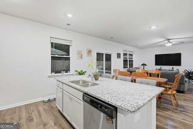 a kitchen with stainless steel appliances a sink a stove a table and chairs