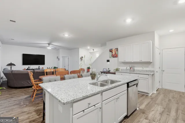 a kitchen with granite countertop a sink stove and refrigerator