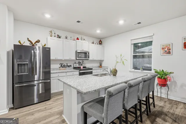 a kitchen with granite countertop a sink a stove and cabinets