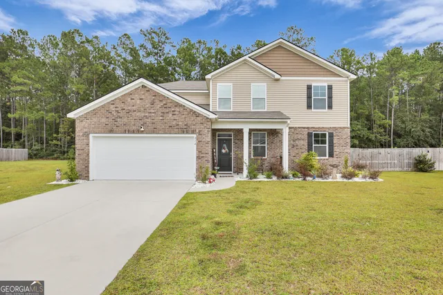 a front view of a house with yard and green space