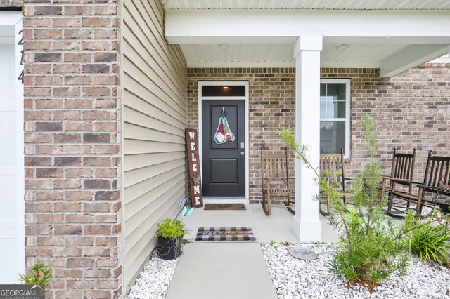 a front view of a house with a potted plant and a window