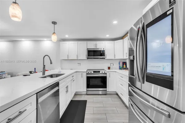 a kitchen with a sink stainless steel appliances and cabinets