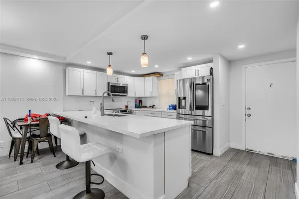a kitchen with refrigerator cabinets and wooden floor