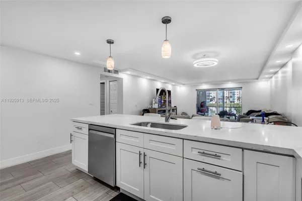 a kitchen with kitchen island a sink stainless steel appliances and cabinets