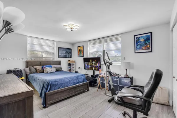 a bedroom with a bed a desk and chair with wooden floor