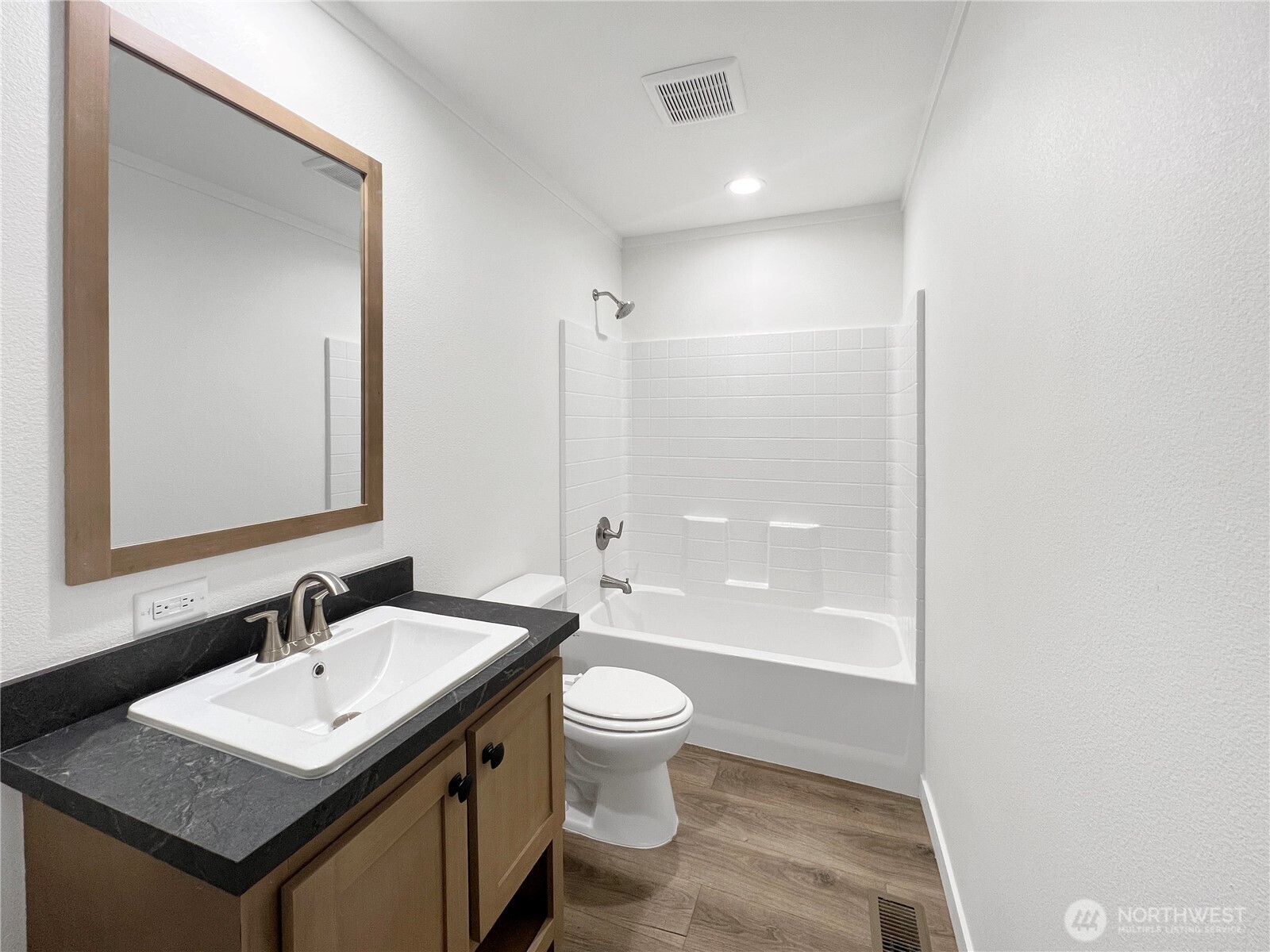 10900 Kuhlman Road Southeast, Unit 84 Olympia, WA 98513 - Photo 18 of 20 a bathroom with a sink a toilet a mirror and a tub