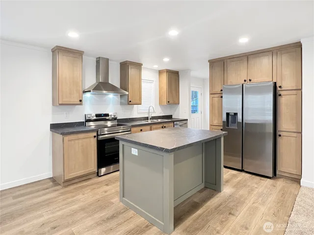 a kitchen with stainless steel appliances granite countertop a stove a refrigerator and a sink