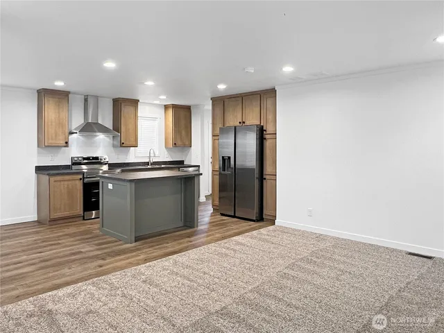 a kitchen with stainless steel appliances granite countertop a stove a refrigerator and a sink