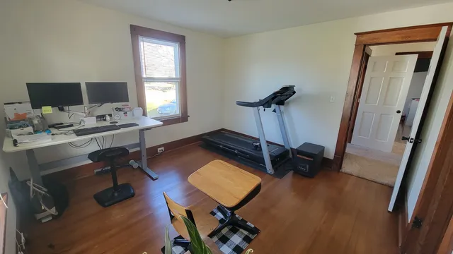 a view of a workspace with furniture and a window