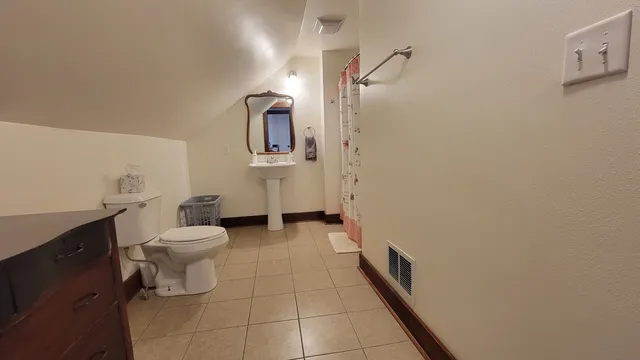 a bathroom with a toilet sink and mirror