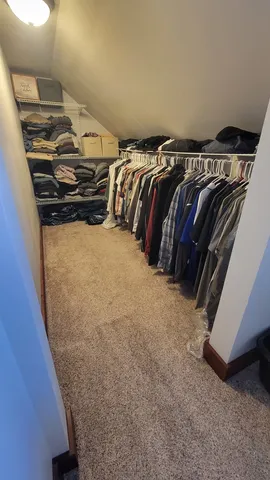 a view of walk in closet with clothes