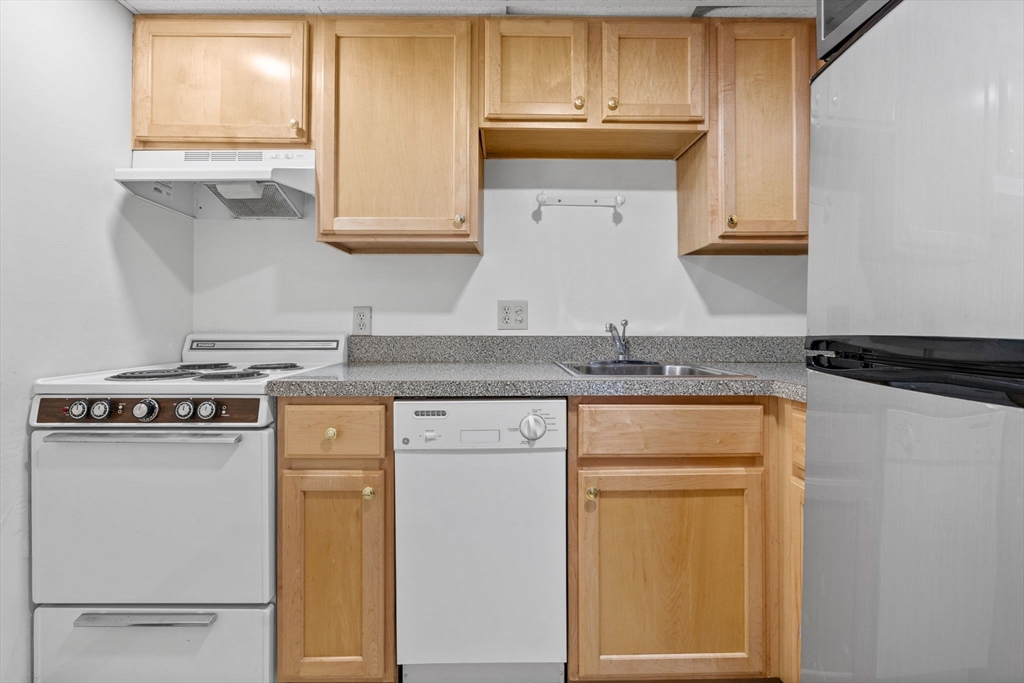 466 Commonwealth Avenue, Unit 305 Boston, MA 02215 - Photo 8 of 14 a kitchen with granite countertop cabinets stainless steel appliances and a window
