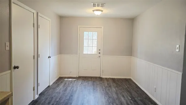 a kitchen with a refrigerator and white cabinets