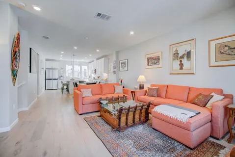 a living room with furniture kitchen view and a couch