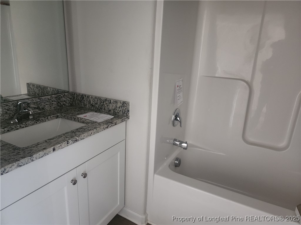 207 Barnsley Road Angier, NC 27501 - Photo 12 of 16 a bathroom with a granite countertop sink a toilet and shower