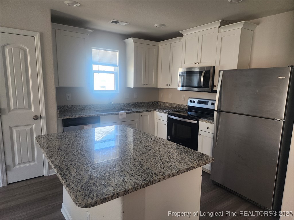 207 Barnsley Road Angier, NC 27501 - Photo 8 of 16 a kitchen with granite countertop a refrigerator a sink a stove a microwave and island