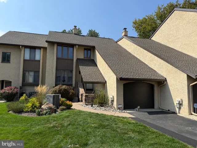 a front view of a house with a garden and plants