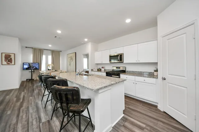 a kitchen with white cabinets and chairs