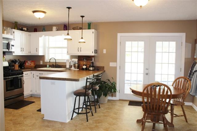 7239 Maple Springs Road Manchester, TN 37355 - Photo 10 of 20 DINING ROOM AND KITCHEN W/BAR AND DOOR TO DECK AND POOL.