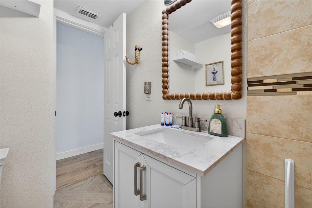 14251 Gulf Boulevard, Unit 5 Madeira Beach, FL 33708 - Photo 14 of 18 a bathroom with a sink and a mirror