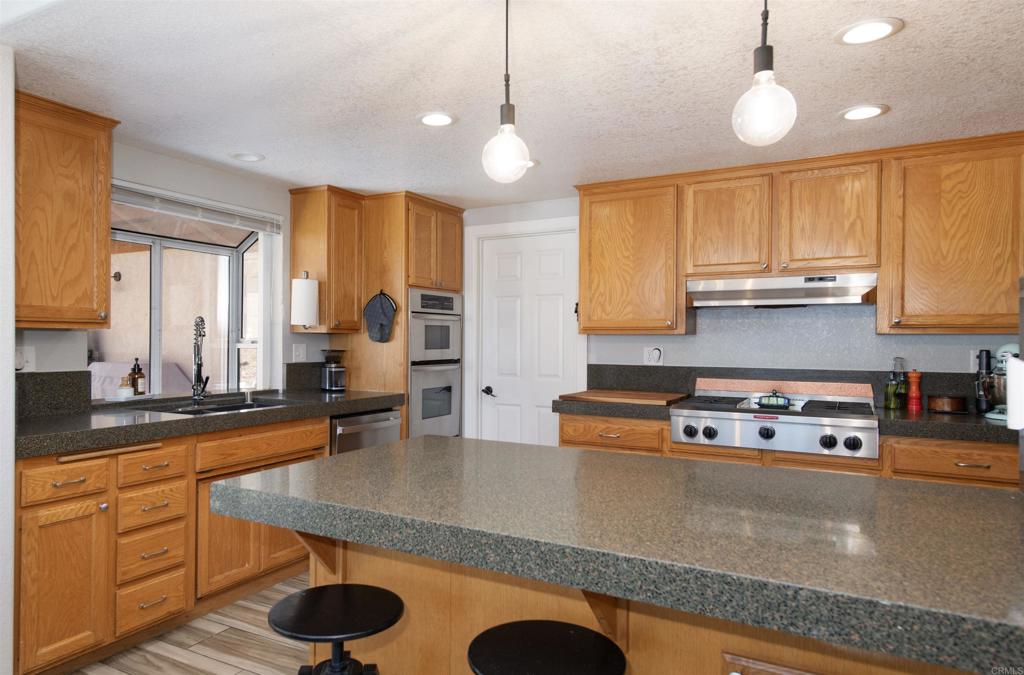 346 Oak Street Ramona, CA 92065 - Photo 15 of 31 a kitchen with stainless steel appliances granite countertop a sink a stove and a wooden floors
