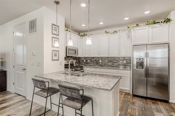 a kitchen with kitchen island granite countertop a counter space and stainless steel appliances