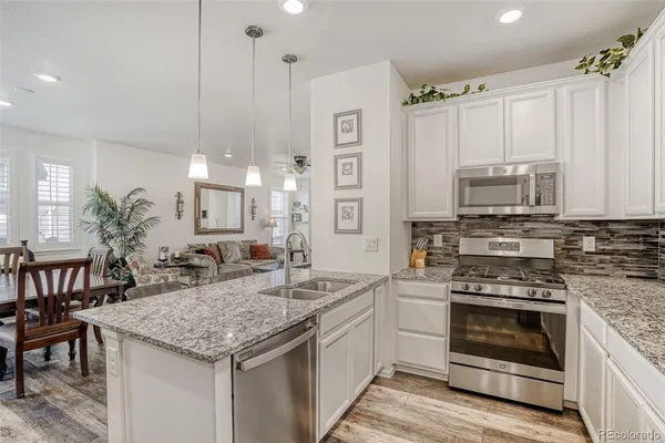 a kitchen with granite countertop a stove and cabinets