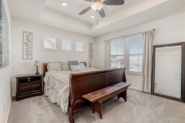 a bedroom with a bed a dresser and a chandelier