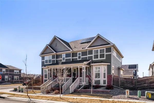 a view of a big house with a small yard and large tree