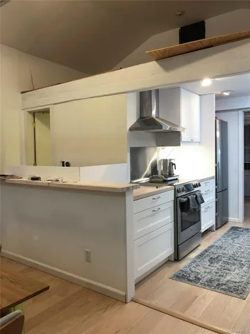 a kitchen with granite countertop a stove and cabinets