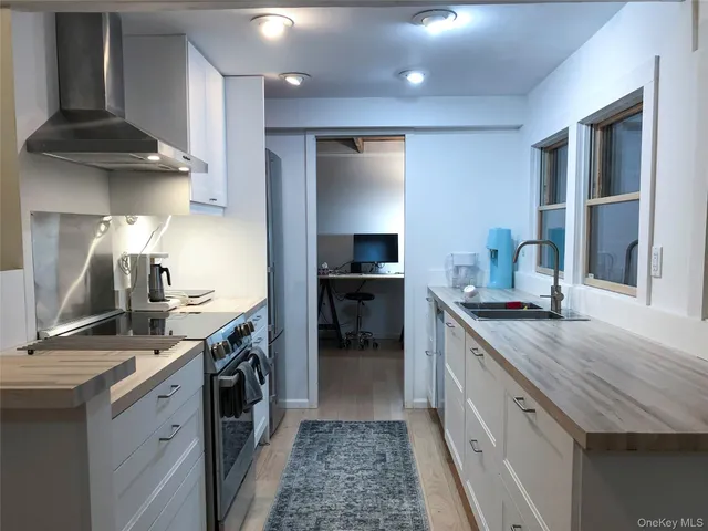 a kitchen with granite countertop a sink stove and cabinets