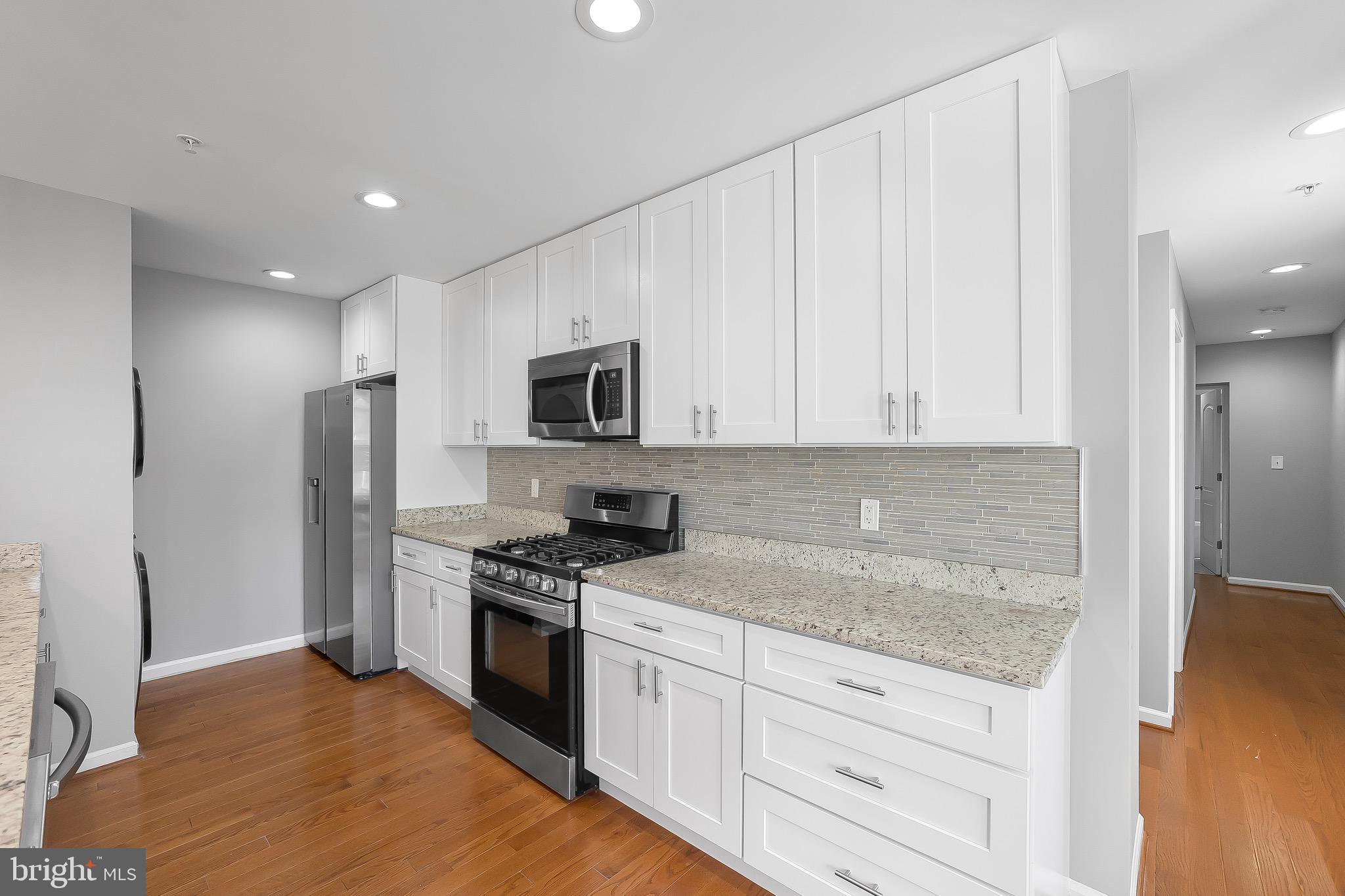 2917 13th Street Northwest Washington, DC 20009 - Photo 7 of 33 a kitchen with granite countertop white cabinets and stainless steel appliances