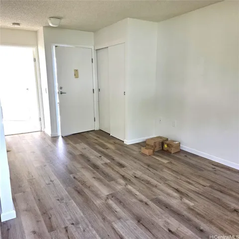 a view of empty room with wooden floor