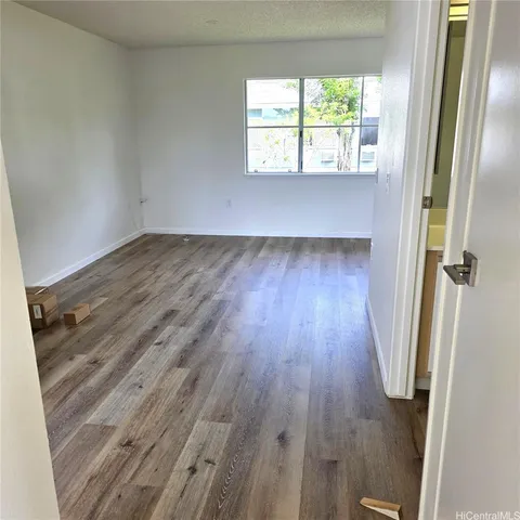 an empty room with wooden floor and a window