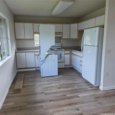 a kitchen with a refrigerator and a stove top oven