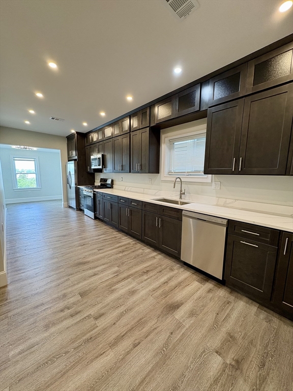 a large kitchen with stainless steel appliances kitchen island granite countertop a sink and cabinets