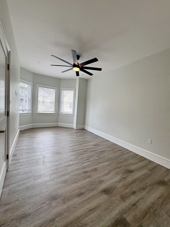 54 Falcon Street, Unit 54 Boston, MA 02128 - Photo 14 of 19 wooden floor in an empty room with a window
