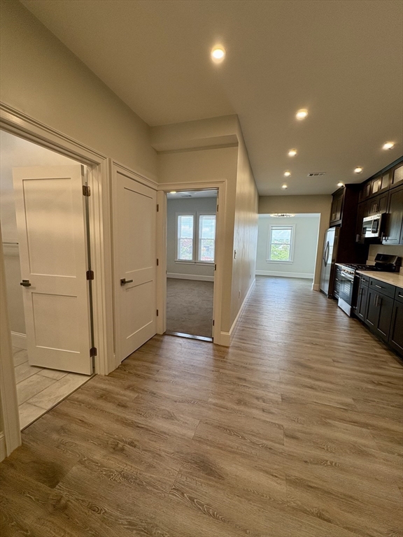54 Falcon Street, Unit 54 Boston, MA 02128 - Photo 5 of 19 an empty room with wooden floor and windows