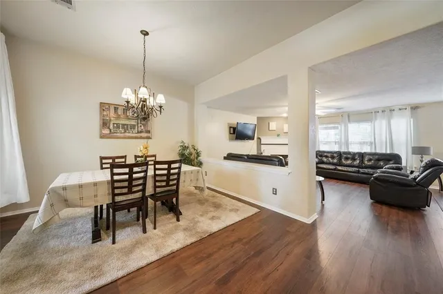 a dining room with furniture a chandelier and wooden floor