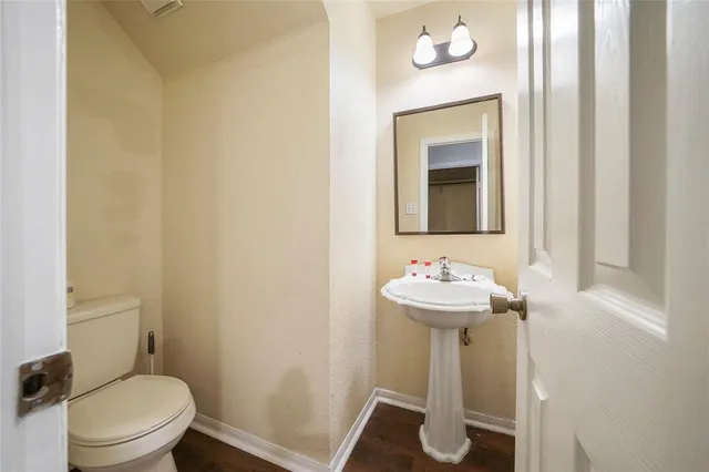 a bathroom with a sink mirror and toilet