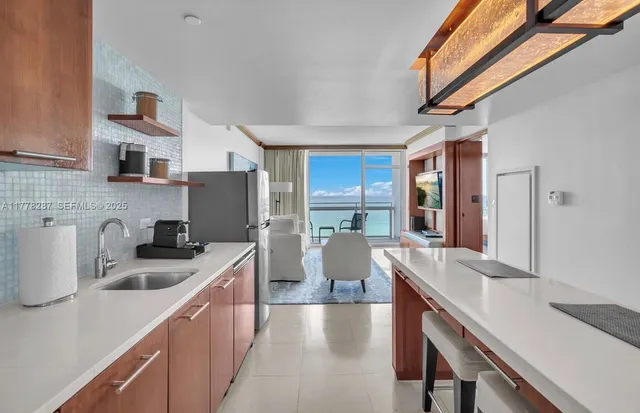 a kitchen with stainless steel appliances a sink a stove a refrigerator cabinets and a counter top space