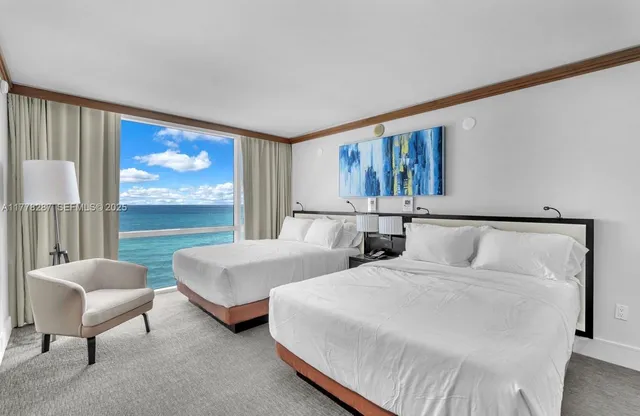 a spacious bedroom with two beds and a large window