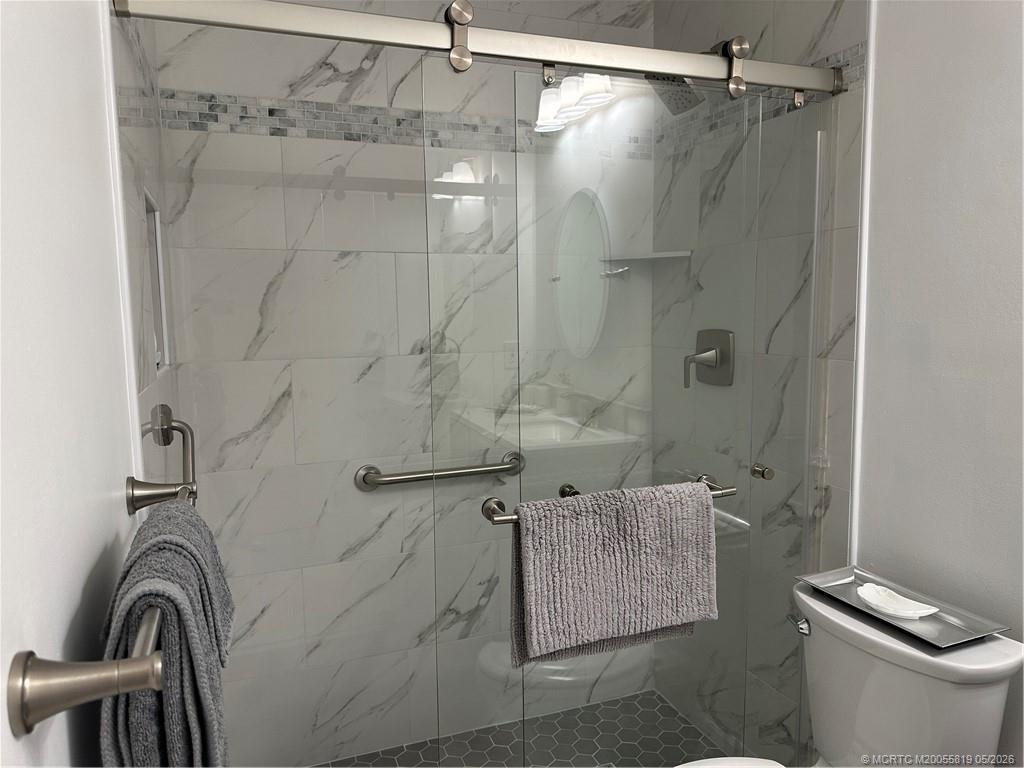 755 Saturn Street, Unit F205 Jupiter, FL 33477 - Photo 13 of 19 a bathroom with a shower a toilet and sink