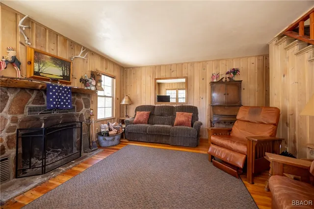 a living room with furniture and a dining table next to a window