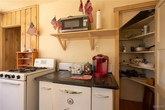a kitchen with white cabinets and sink