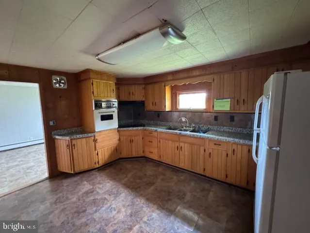 a kitchen with granite countertop white cabinets white stainless steel appliances and window