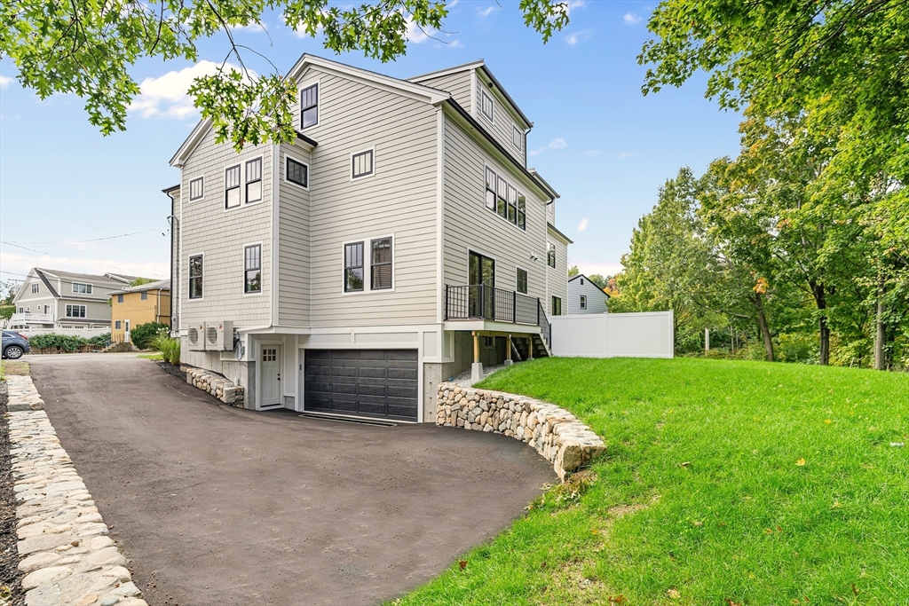 12 Guild Road, Unit 12 Needham, MA 02494 - Photo 31 of 32 a front view of a house with a yard and garage