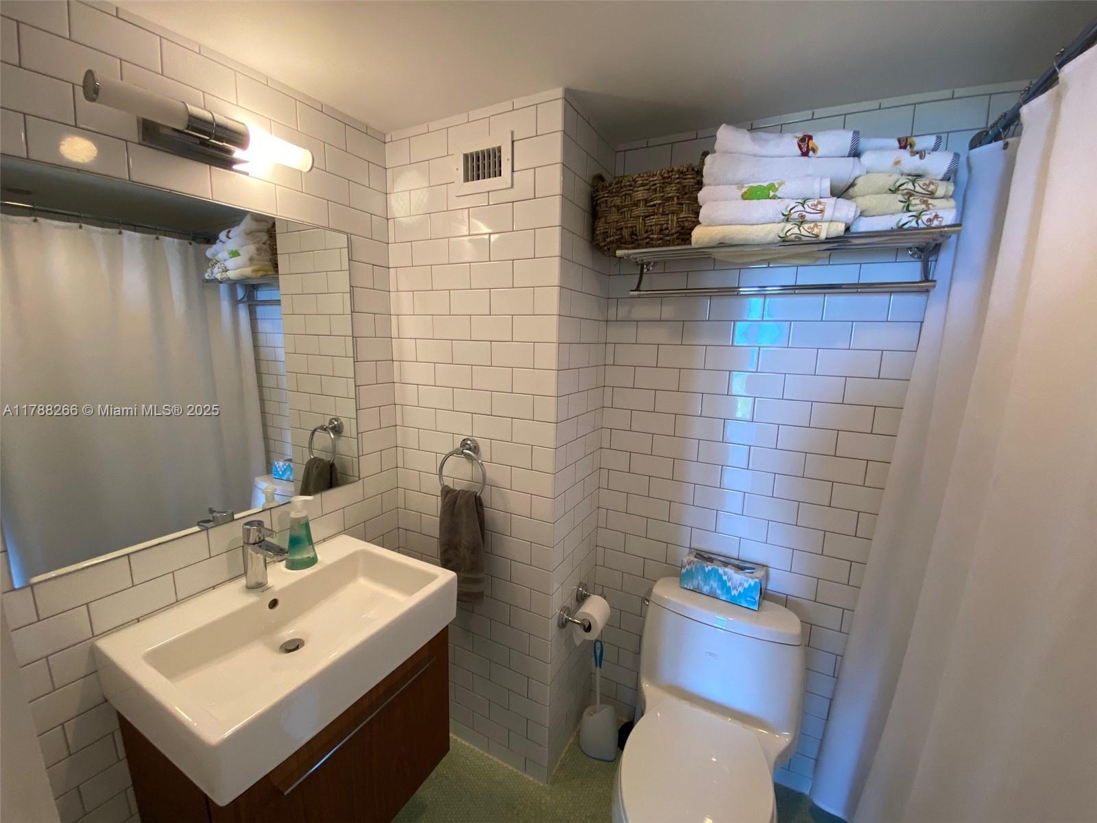 150 Southeast 25th Road, Unit 7A Miami, FL 33129 - Photo 13 of 18 a bathroom with a sink mirror and toilet