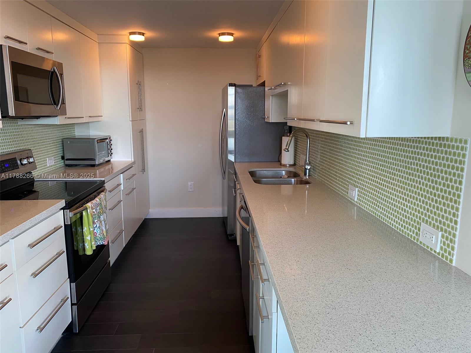 150 Southeast 25th Road, Unit 7A Miami, FL 33129 - Photo 6 of 18 a kitchen with a sink a stove top oven and refrigerator